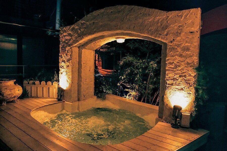 Einladender Jacuzzi im Freien, beleuchtet bei Nacht im The Bungalow in Itaewon, Seoul.