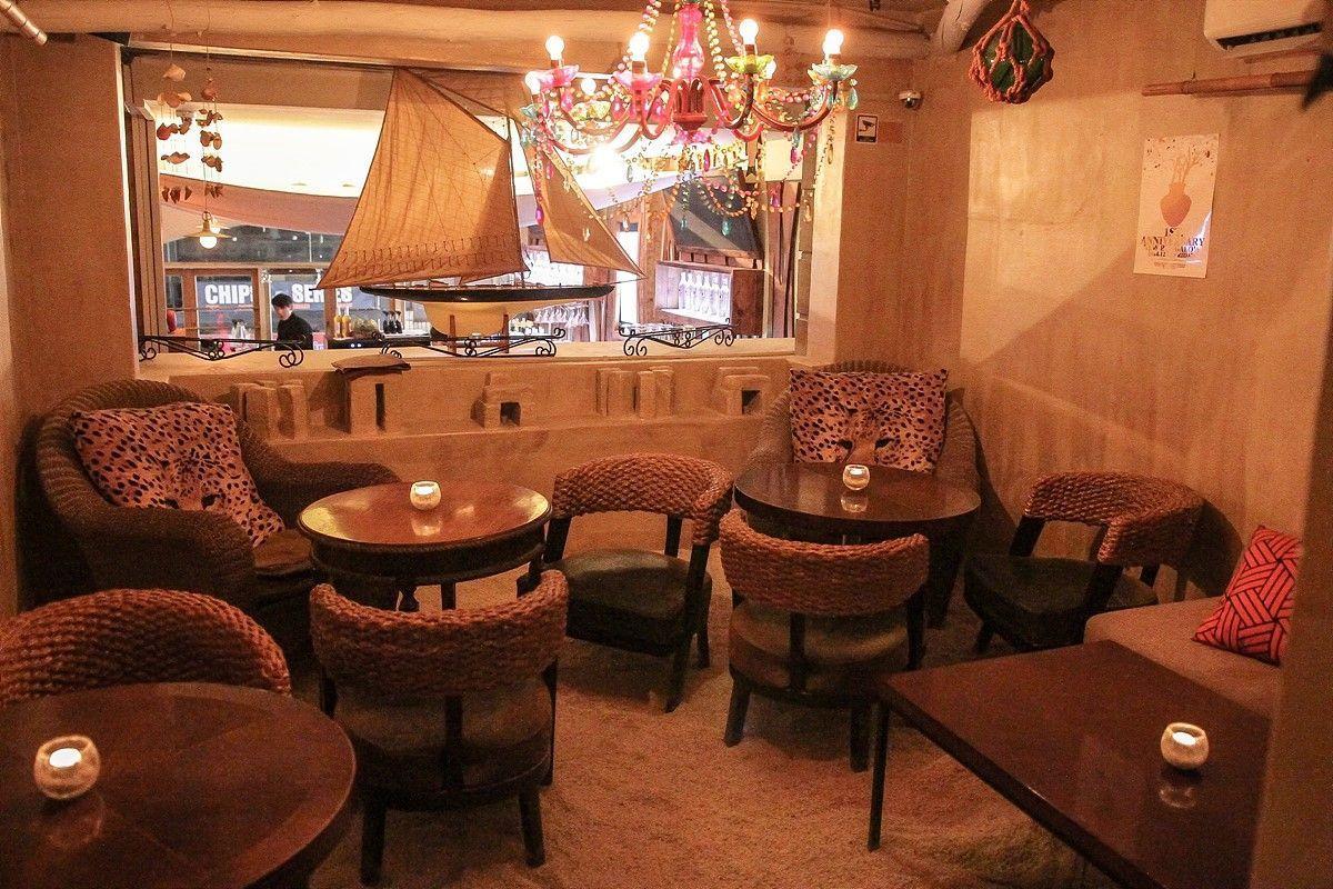 Gemütliches Ambiente im Inneren der Itaewon Bar The Bungalow mit Stranddekor und Kerzenlicht.