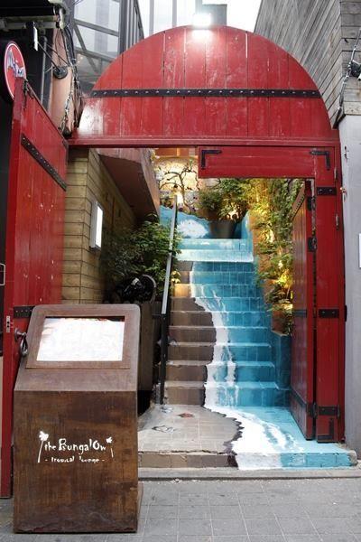 Eingang zur exotisch gestalteten Bar 'The Bungalow' in Itaewon, Seoul, mit kreativer Malerei.