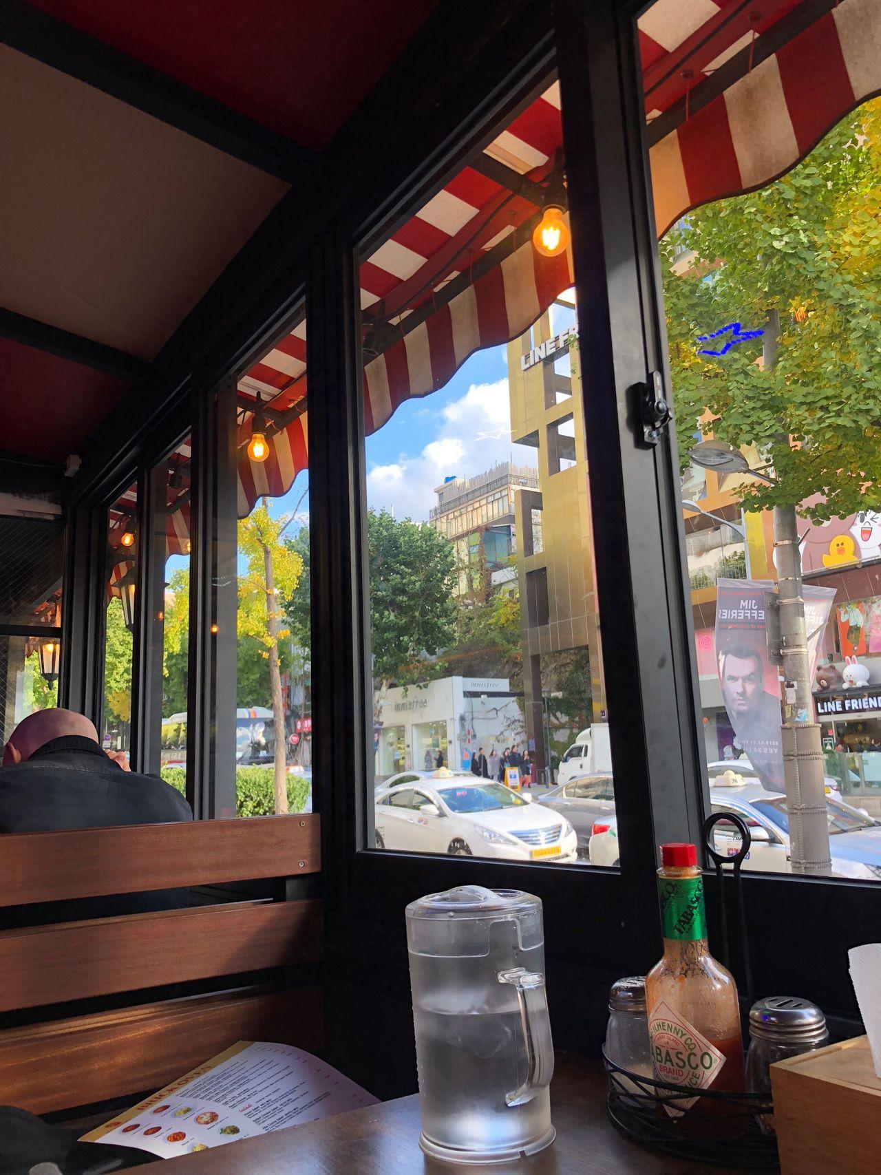 Innenansicht eines Restaurants mit Blick auf die Straße in Itaewon, Seoul, mit einem gemütlichen Ambiente.