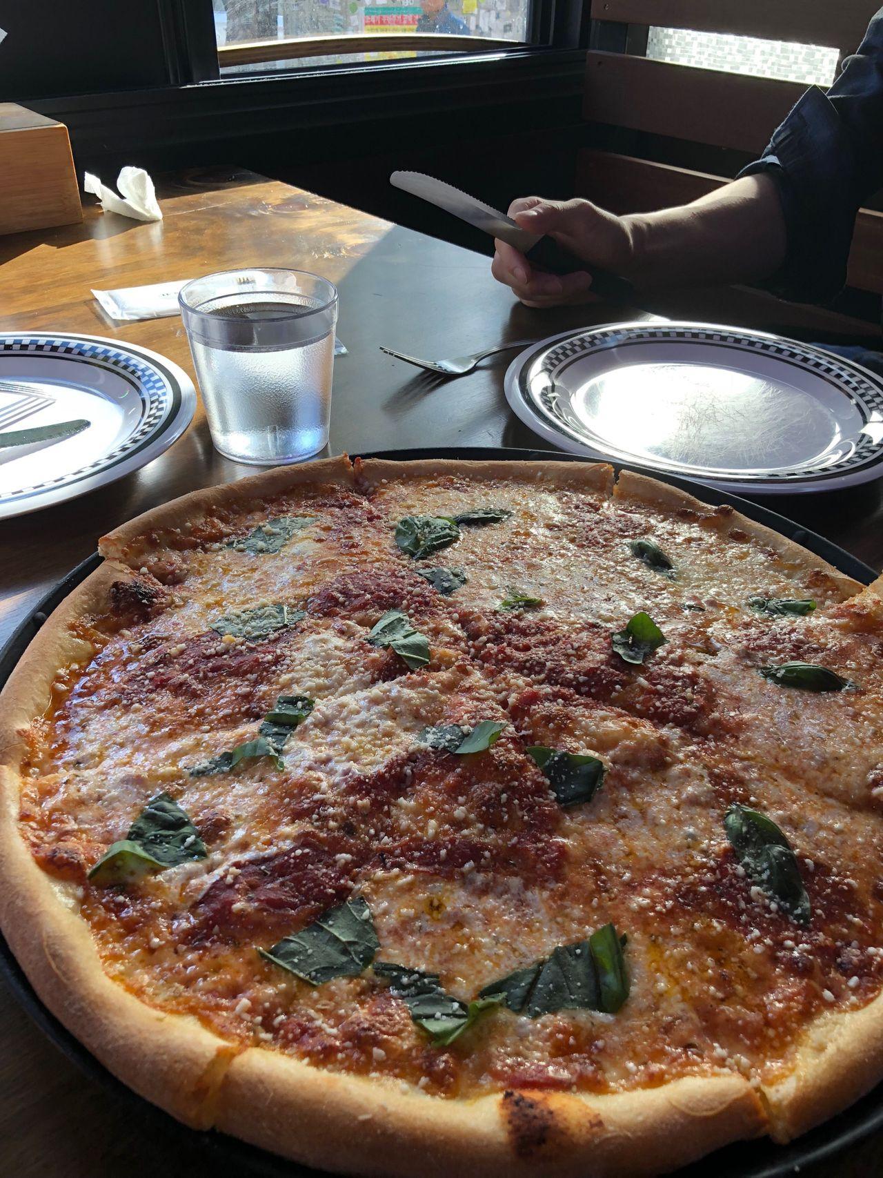 Große klassische Pizza serviert in einem Itaewon-Restaurant in Seoul, mit lebendiger Atmosphäre.