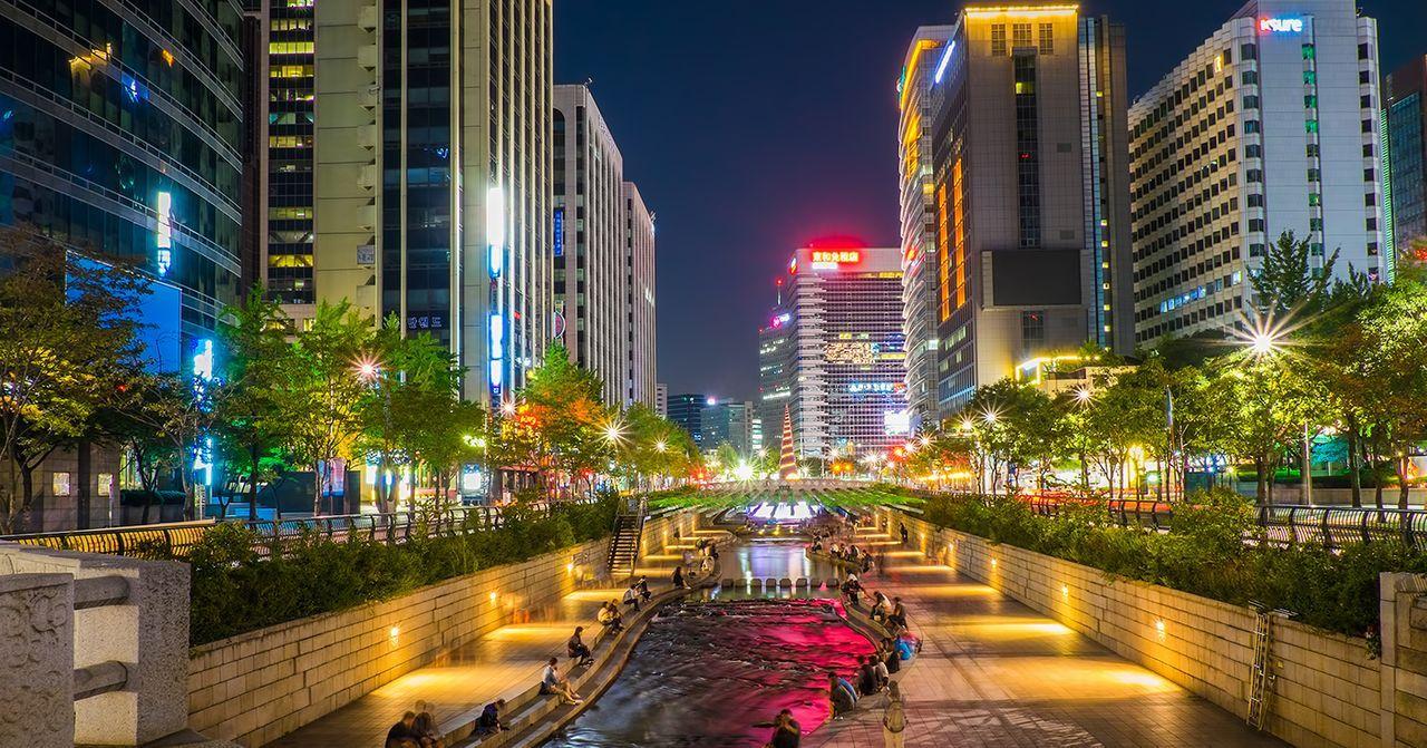 首爾市中心的清溪川夜景，河流兩旁的高聳建築在燈光映照下顯得格外璀璨。