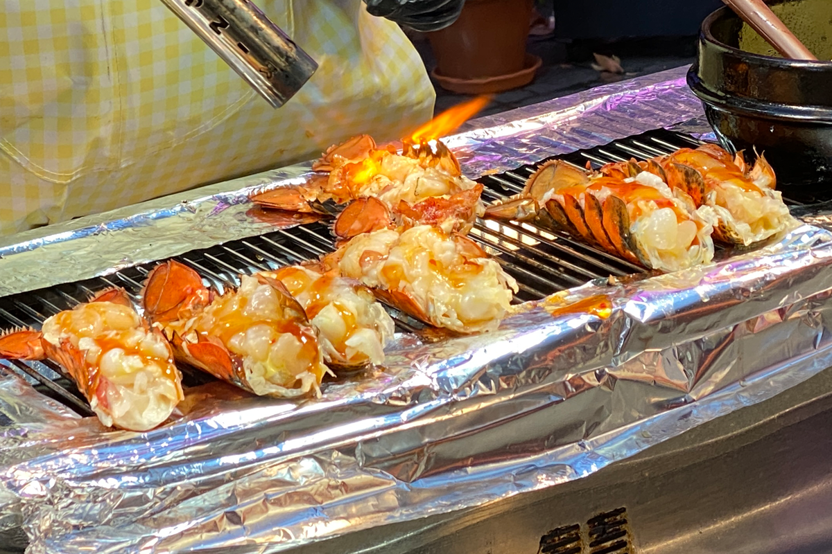 明洞街頭燒龍蝦美食，炭燒龍蝦加芝士，香氣四溢。