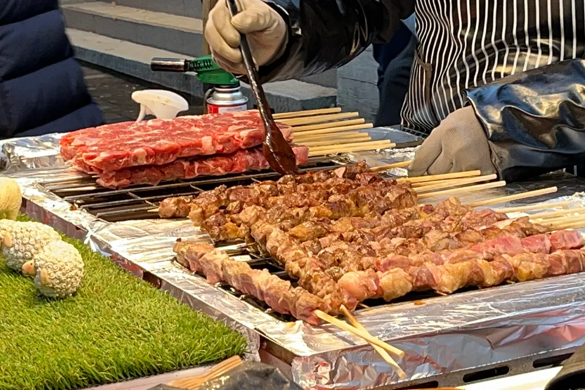明洞街頭羊肉串小吃，加孜然粉烤羊肉香氣迷人。
