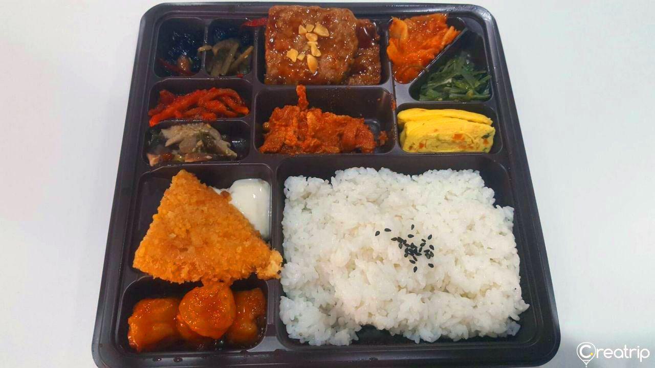 7-11便利商店的11餐便当，包含海带芽、炒泡菜和鸡蛋卷等11种配菜。