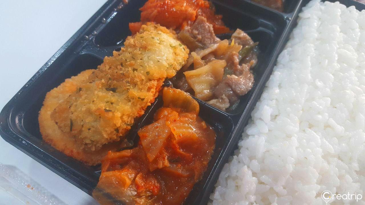 CU万能辣炒饭便当，展示多种配菜，泡菜和辣炒饭的混合风味。