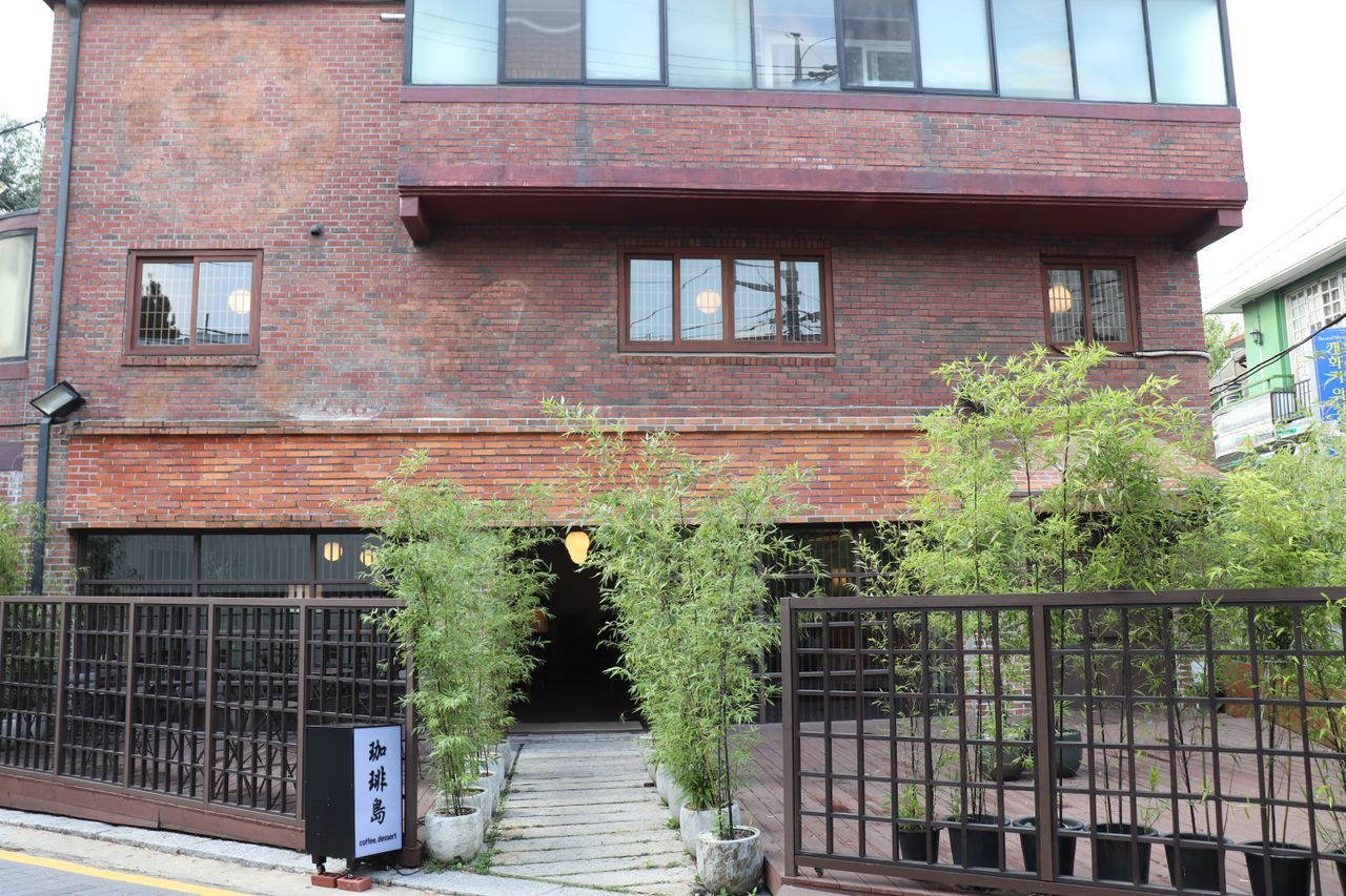 Exterior view of the Gabaedo Samcheongdong café building with a brick facade and bamboo plants
