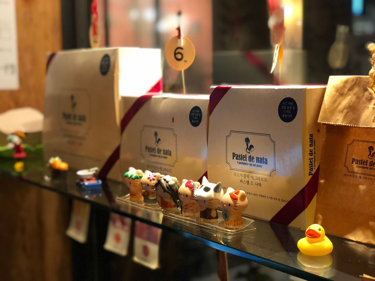 Close-up of Pastel de Nata packaging and small decorative figures