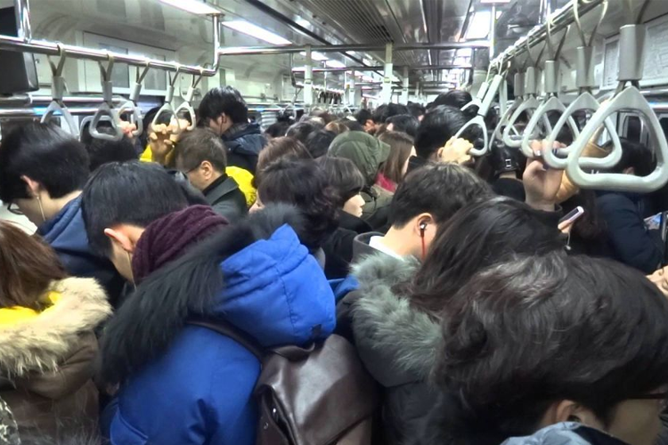 Crowded subway scene showcasing intimacy and public space sharing, a norm in busy South Korean urban life.