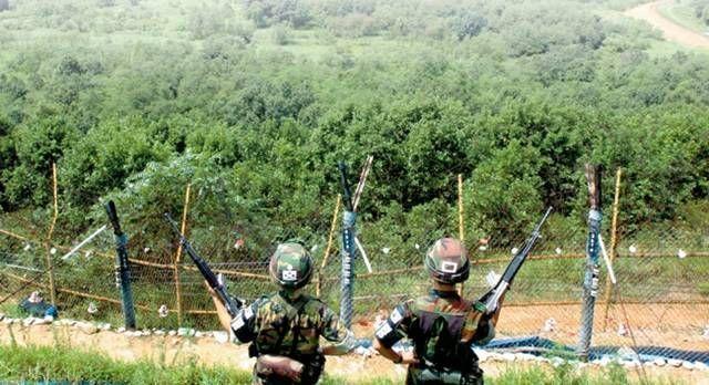 兩名韓國士兵站在邊境，背景是滿布綠色植被的非武裝地帶（DMZ），象徵著南北韓緊張的軍事現狀。