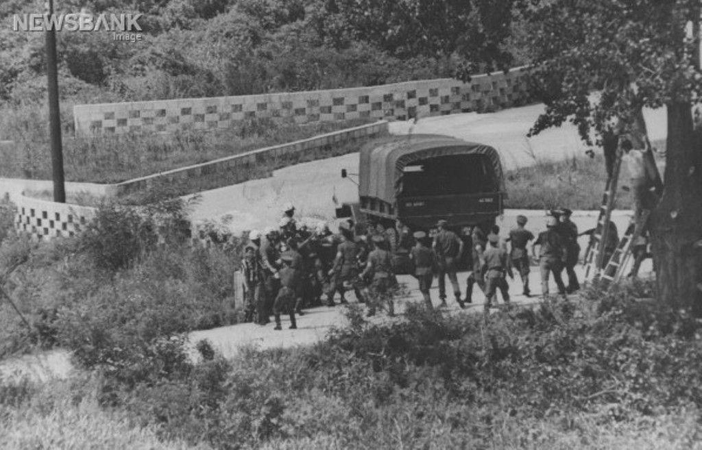 黑白照片捕捉了板門店事件的場景，多名士兵聚集在軍用卡車周圍，這是南北韓間某次軍事事件的紀錄。