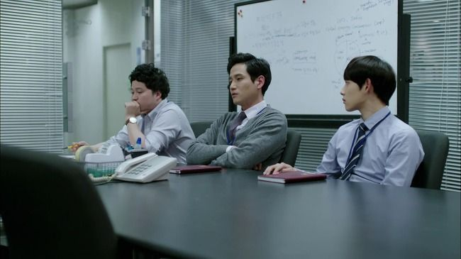 三名韓國公司員工正在開會，坐在會議桌旁，表達對上司指示的順從，反映《未生》的職場氛圍。