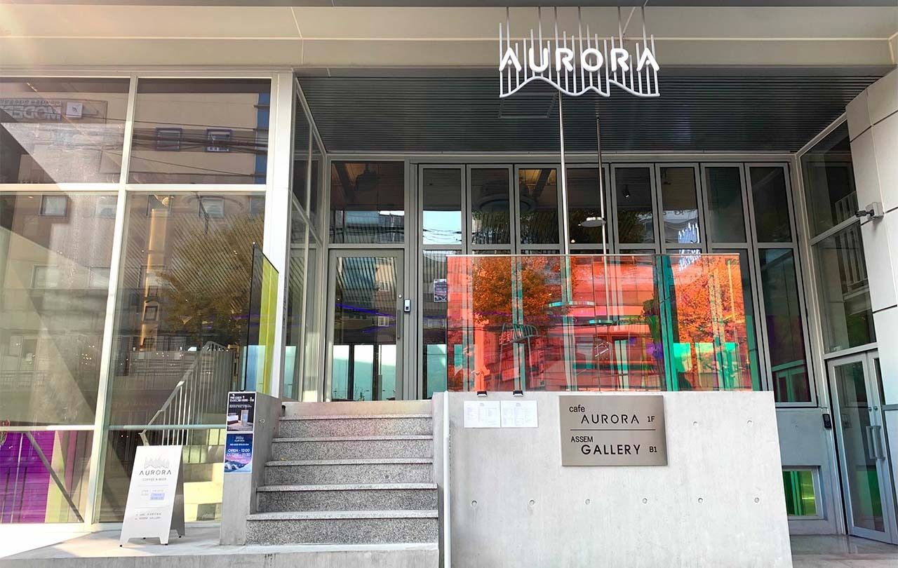 Modern and colorful entrance of Cafe Aurora in Hongdae, attracting visitors with its vibrant aesthetic.