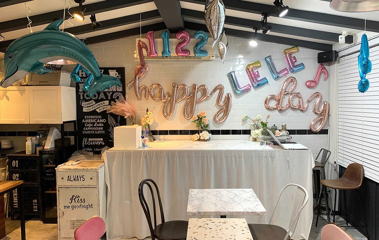 Interior of Lovin' Her cafe, styled for a themed celebration with decorative balloons and festive displays.