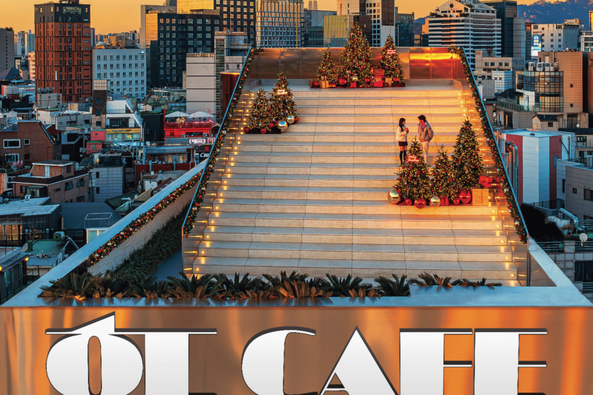 韓国・서울 마포구に位置するهـㄷカフェの屋上で、夕焼けに染まる階段と飾られたクリスマスツリーを背景にしている場面を写した写真。