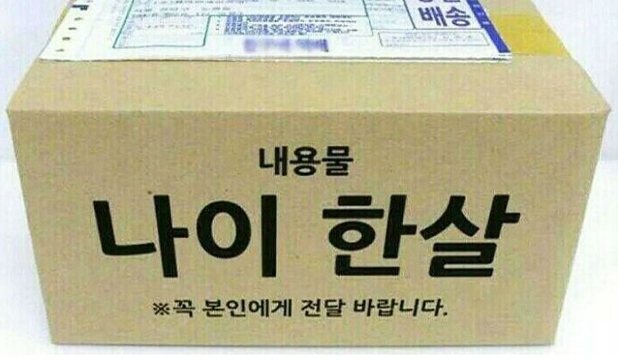 一个纸箱上写着韩文，内容大意为计算韩国年龄的某种方式，箱子用语强调内容重要性，意在强调年龄计算的重要信息。