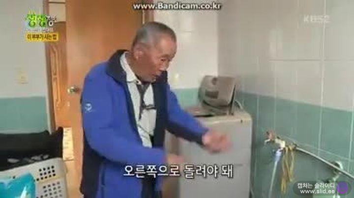 Older Korean man demonstrating an appliance, reflecting traditional lifestyle and knowledge sharing.