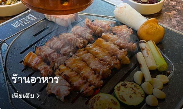 เนื้อย่างเกาหลีที่ร้านอาหารในย่านซอชนที่ถูกปรุงบนเตาร้อน ๆ พร้อมผักเครื่องเคียงหลากหลายบนโต๊ะอาหารที่มีรายละเอียดเกี่ยวกับร้านอยู่ที่ด้านล่าง