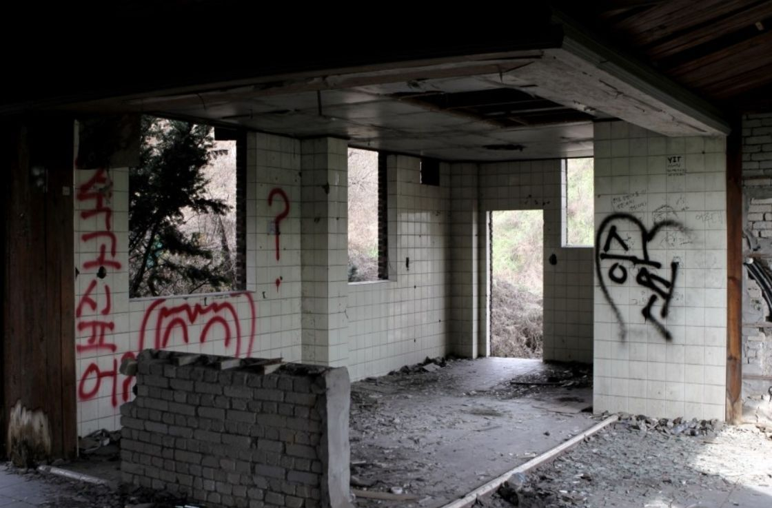 Nội thất bỏ hoang của ngôi nhà ma ám với tường ốp gạch và graffiti, không gian kỳ quái và cảm giác lạnh lẽo - Neulbomgateun 늘봄가든.