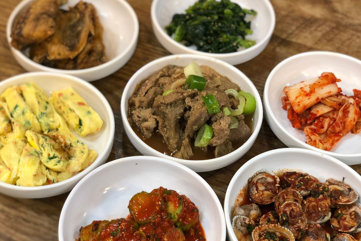 韩国小菜的无限续加文化，源于战后时期为打工族提供更多食物的社交习俗。