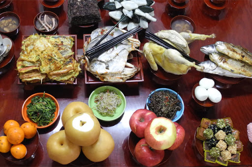 Hidangan tradisional Korea yang disiapkan untuk upacara liburan dengan berbagai makanan di atas meja, mencerminkan praktik budaya dan masakan khas Korea selama acara khusus, seperti Chuseok dan Seollal.