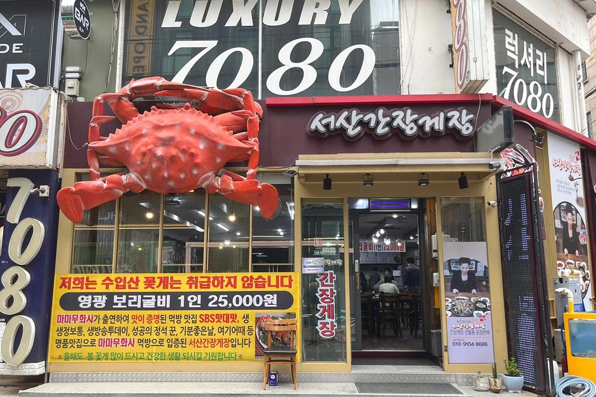 ソウルの『瑞山カンジャンケジャン』の店頭。巨大なカニの看板が特徴的で、訪れる観光客を歓迎する雰囲気を醸し出している。