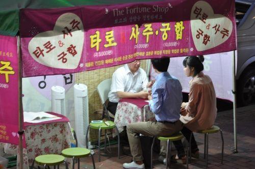 韓國前總統朴槿惠在公開講話旁的祝願儀式，背景展示象徵韓國巫教的裝飾。