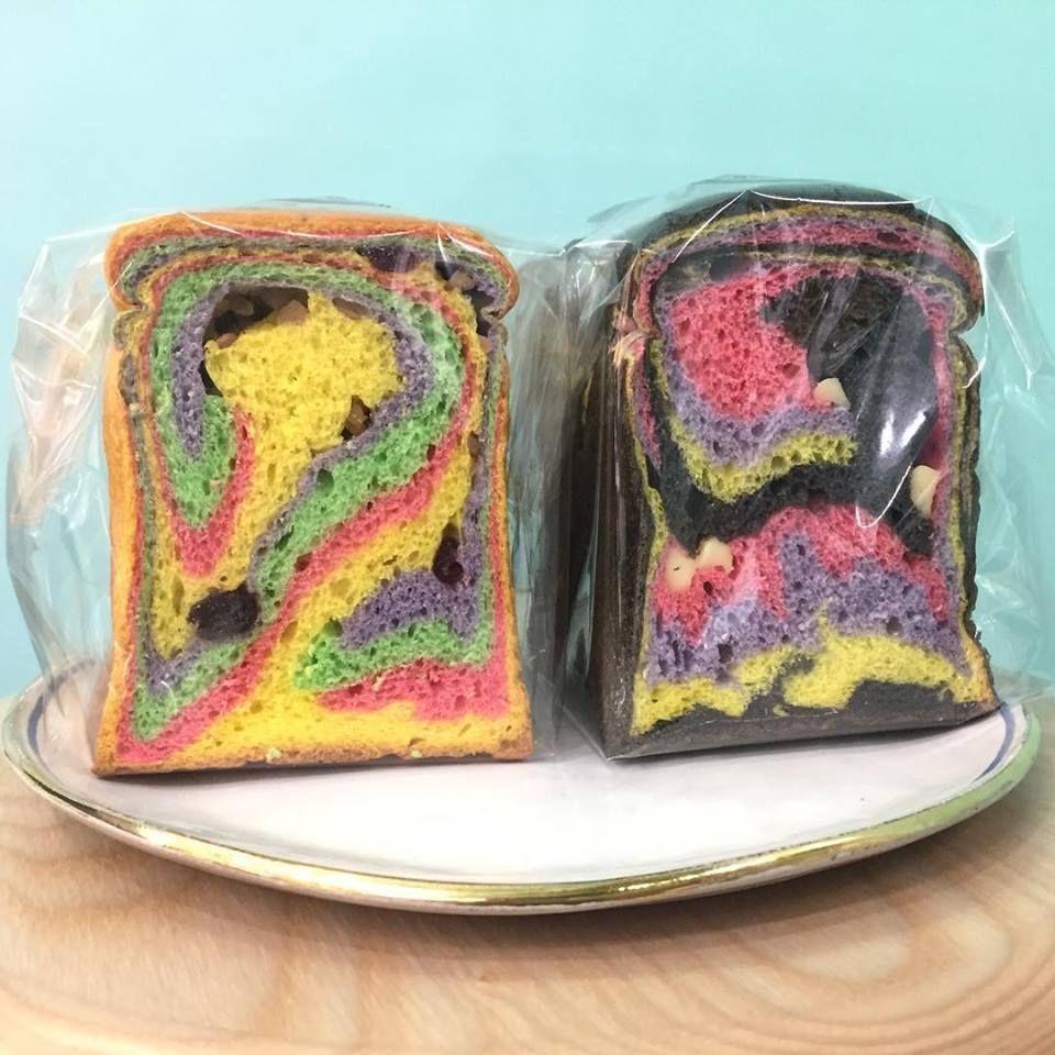 两块彩虹色面包放在银盘上,封在透明包装袋中