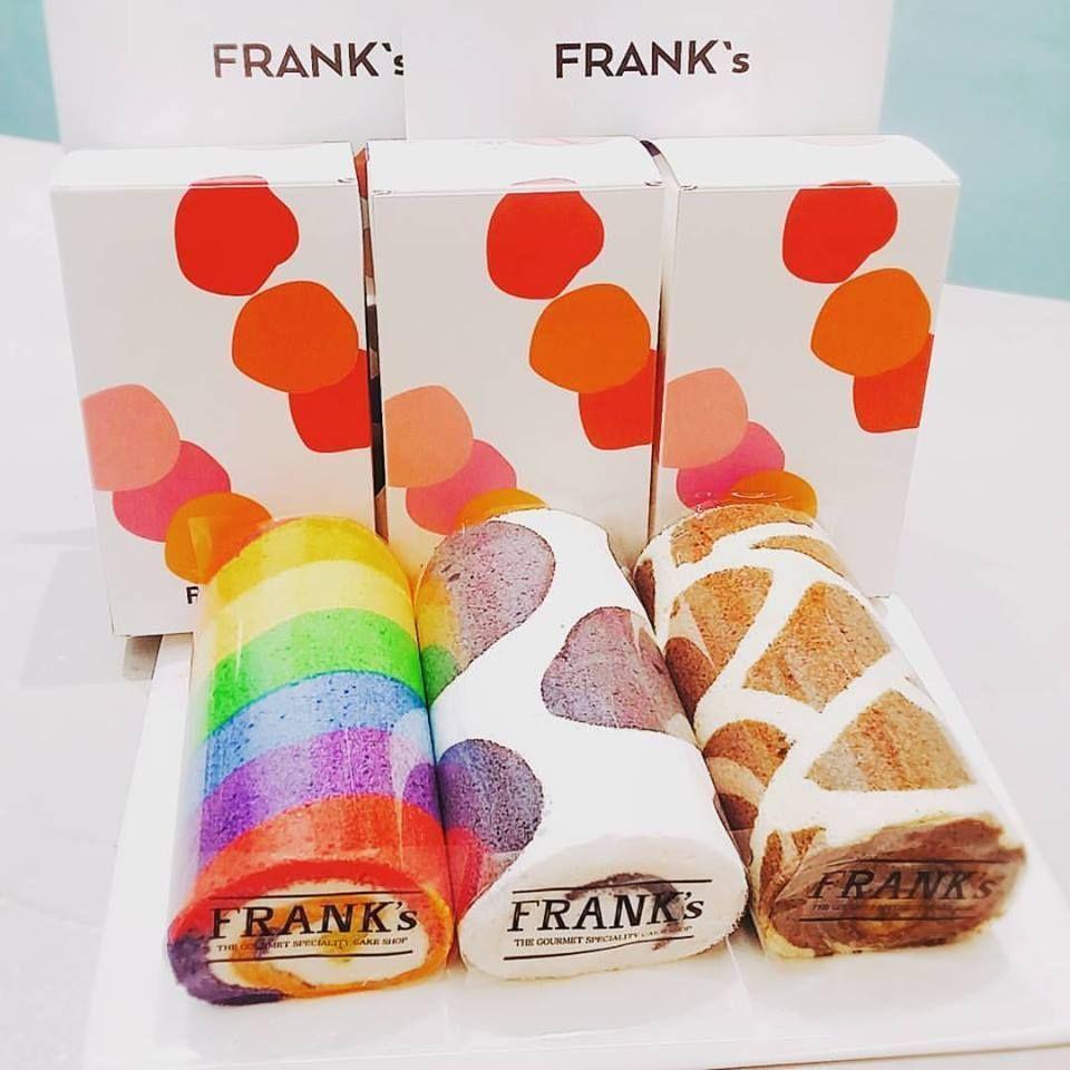 一排 Frank's 彩虹色奶油蛋糕卷,包装纸盒设计与卷内颜色相呼应