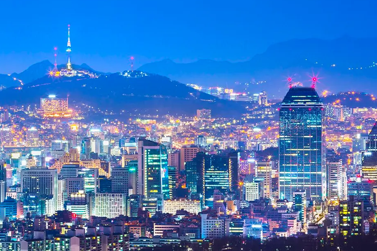 Seoul cityscape at night with skyscrapers and Namsan Tower illuminating the skyline, showcasing the vibrant and bustling atmosphere of South Korea's capital.