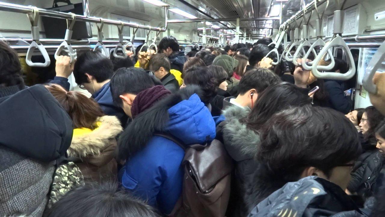 人满为患的韩国地铁车厢，乘客拥挤。