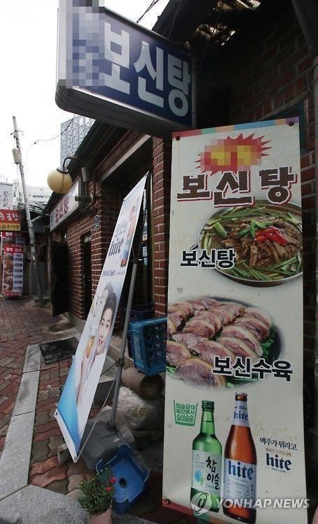 墙上的韩国补身汤店标志，与广告画面对比明显。