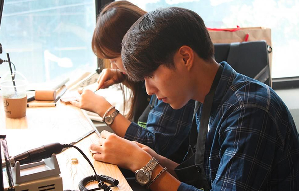 戒指大学里从事手工制作的人们，专注的气氛中学习自制银饰