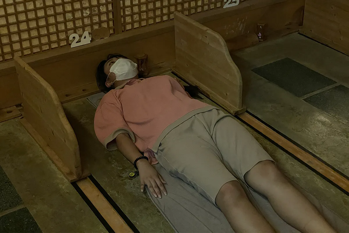 免疫工房中的客人在享受地面按摩，室内装潢温暖舒适