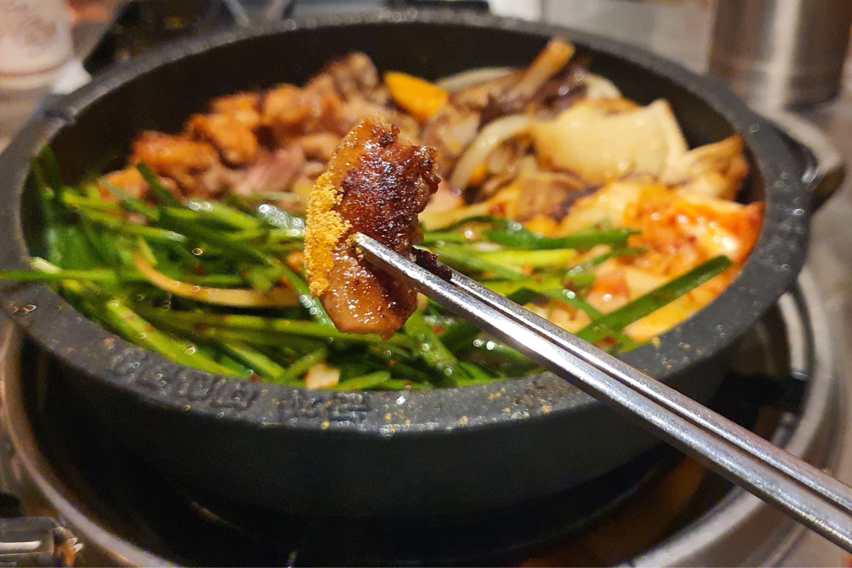 香ばしく炒められたコプチャンを楽しめる韓国の名物料理を提供する様子。