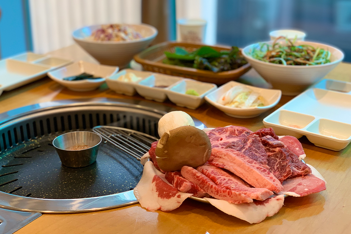 『黄金牧場』で焼かれる最高品質のサムギョプサルの写真。熟成された柔らかいお肉がグリルで焼かれている。