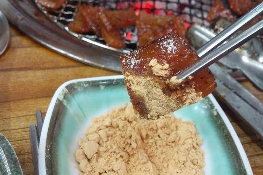 Steaming 삼겹살 on a grill combined with kimchi, highlighting the fusion of traditional Korean flavors