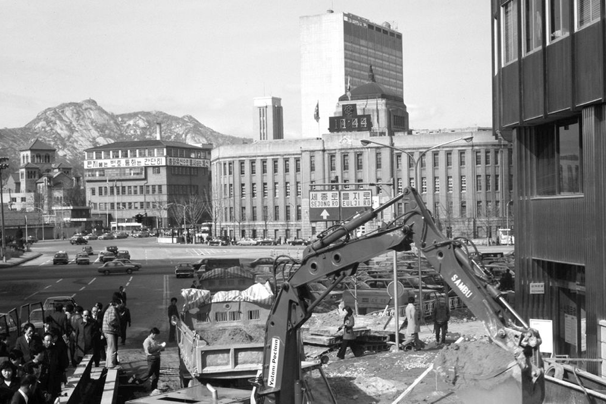 韓國工人在灰塵環境中工作，象徵過去工業化時代的典型場景