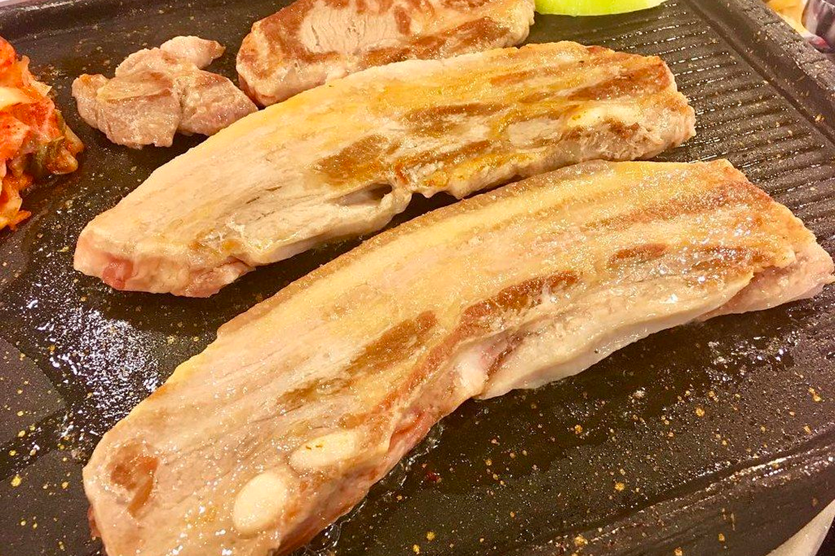 韓國燒烤餐館，桌上擺滿燒肉和多樣化的配菜