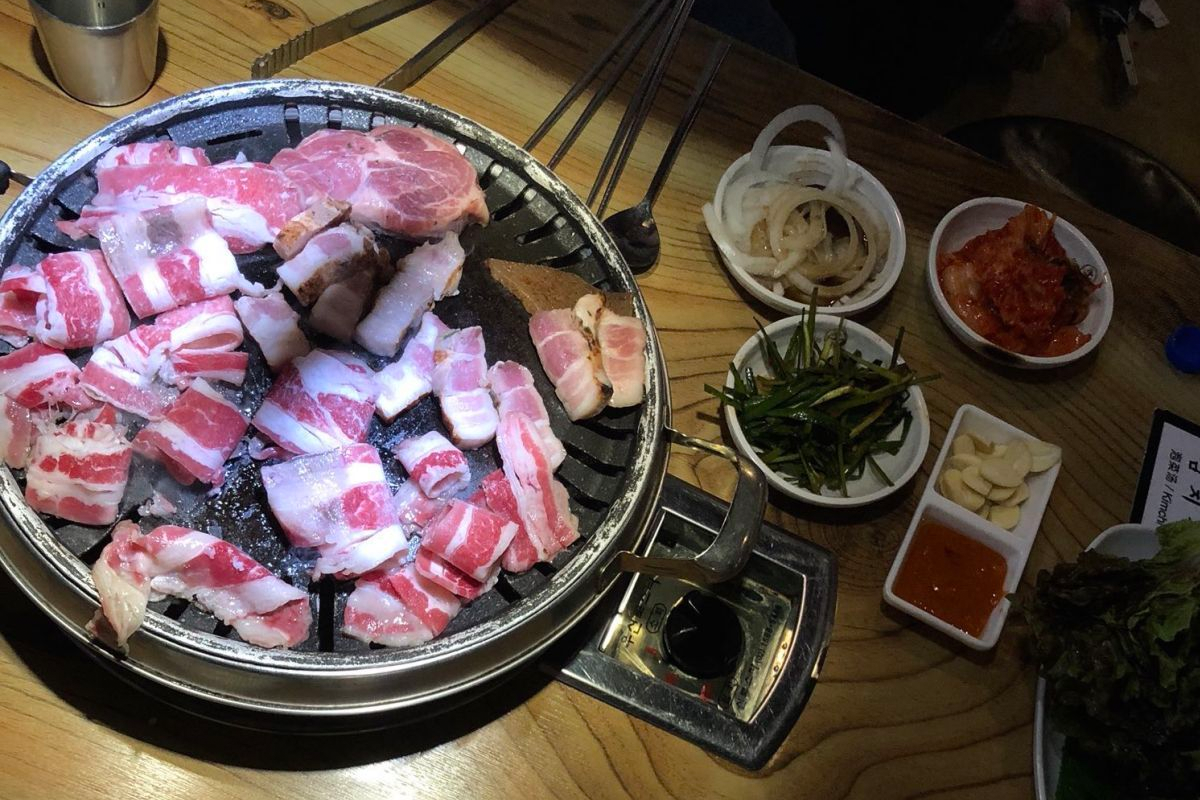 炙燒金黃的五花肉，搭配生菜、泡菜等新鮮配料