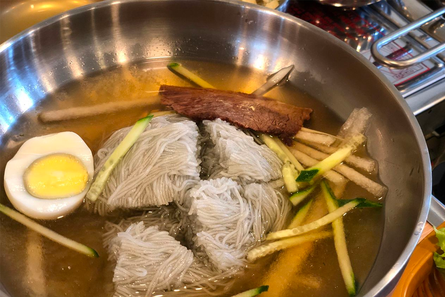 A hot stone bowl with bubbling Korean soup served alongside 삼겹살 to accentuate the harmony of flavors in Korean BBQ