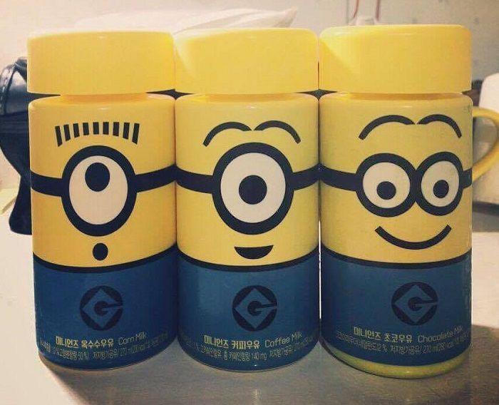 三瓶整齐排列的小黄人牛奶，展示了不同口味：玉米、咖啡和巧克力，每一瓶都有独特的小黄人物。