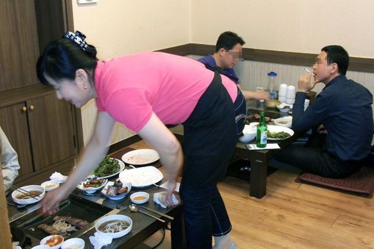 日常韓國餐廳內部服務的女性，強調對服務人員禮貌稱呼的一瞬間