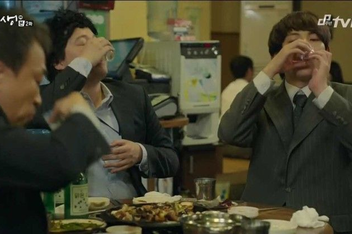 韓國餐廳內部設有傳統燒烤和飲酒的桌上場景，桌上擺放著食物和酒瓶，適合團體聚餐的環境