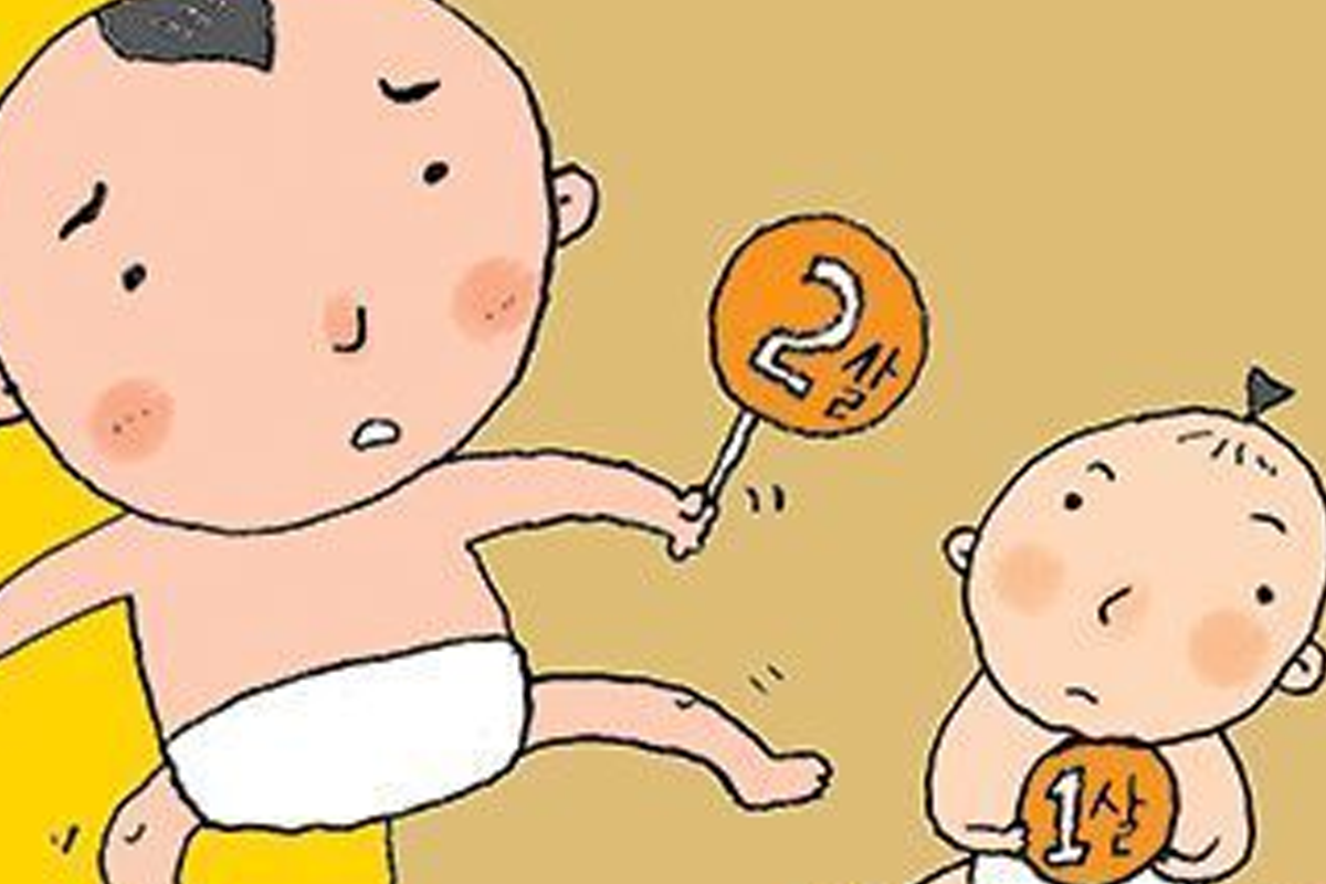 兩個可愛的小孩子，一個年紀較大的持著2歲的標誌，凸顯年齡在韓國社會中的重要性