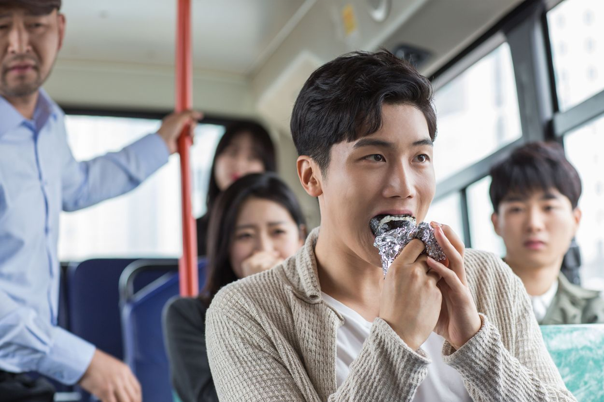 在韓國巴士上的乘客畫面，強調不飲食規定的重要性，為維護公共交通設施清潔