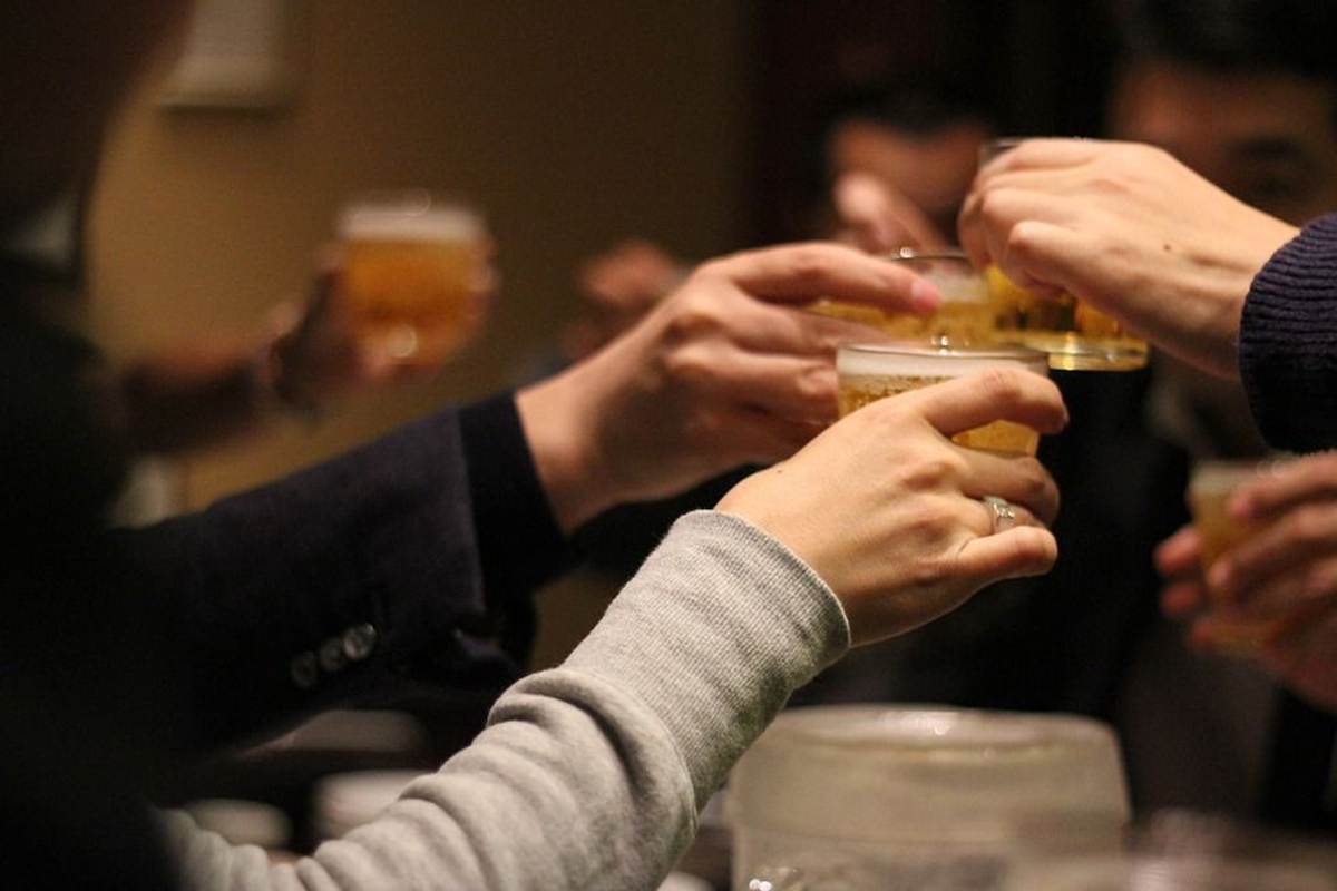 多人一起在進行乾杯的畫面，展示韓國飲酒文化中的友好互動，強調聯誼和宴會場景