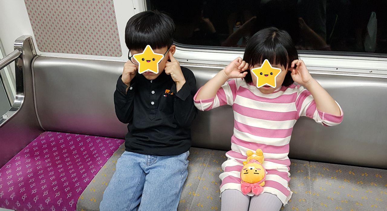 電車のベンチに座っている韓国の子供たち