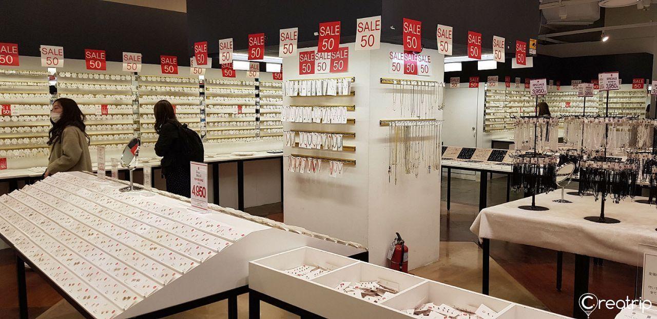 韓国アクセサリーショップSALE 50の店内。多くのイヤリングが展示され、割引セールのサインが目立ちます。