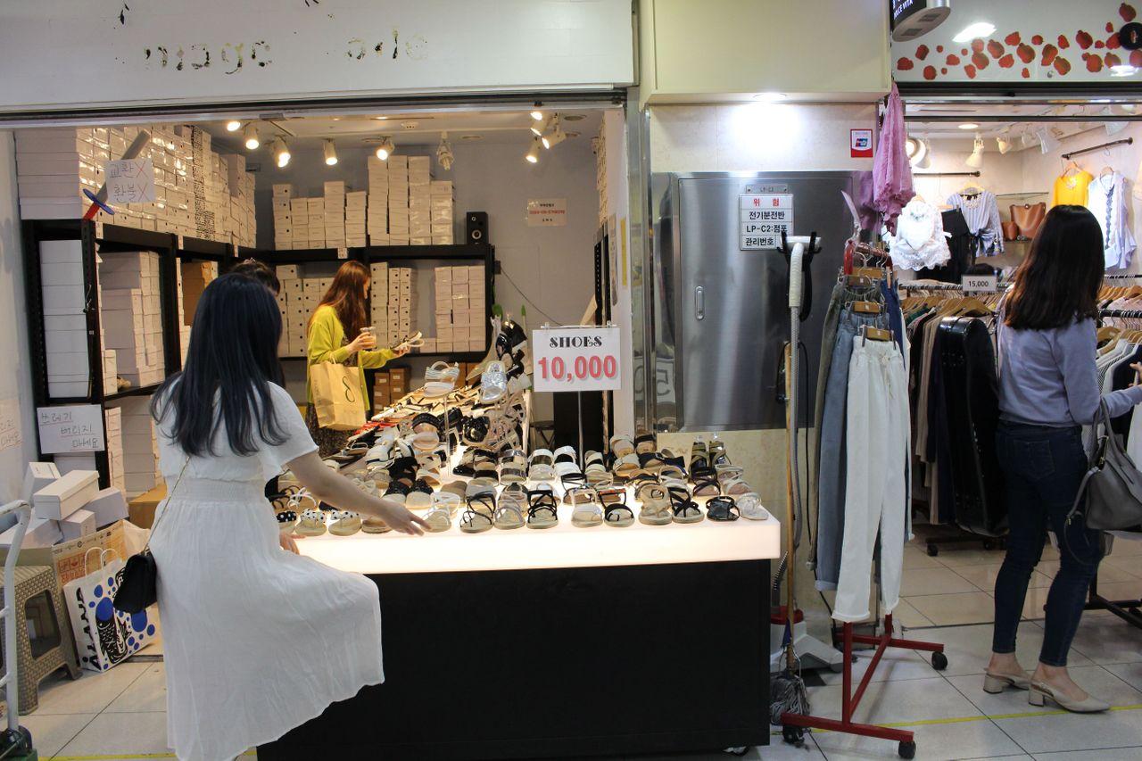 服装店内展示各种色彩丰富的春季服饰，适合年轻女性。